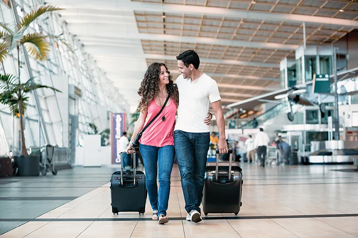 Couple marchant dans un aéroport en route pour les Maldives