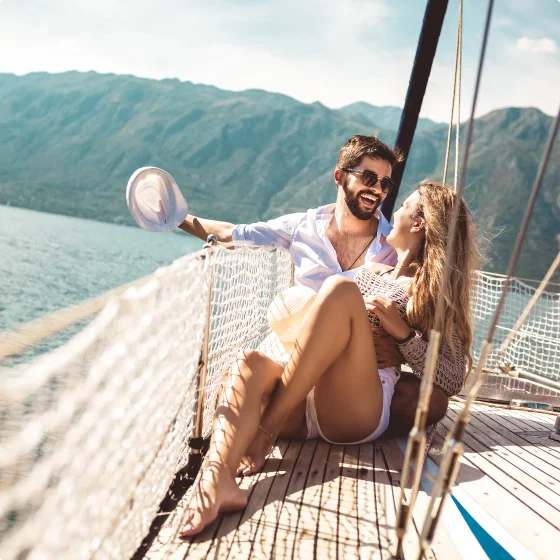 Couple complice en voyage riant sur un bateau
