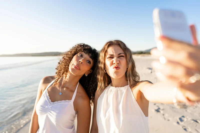 Couple de femmes faisant une grimace etun selfie sur la plage