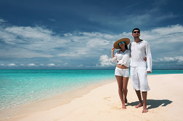 Couple aux Maldives posant sur une plage de sable blanc