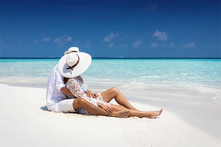 Couple enlacé sur une plage paradisiaque lors de leur voyage de noces aux Maldives