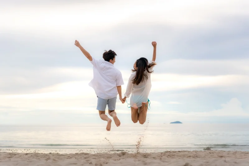 Couple heureux sautant sur une plage