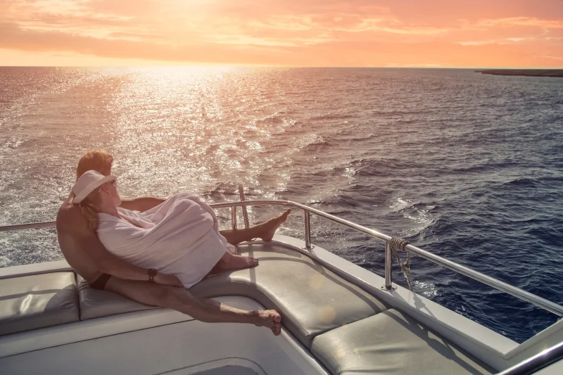 Couple enlacé à bord d’un catamaran au coucher du soleil