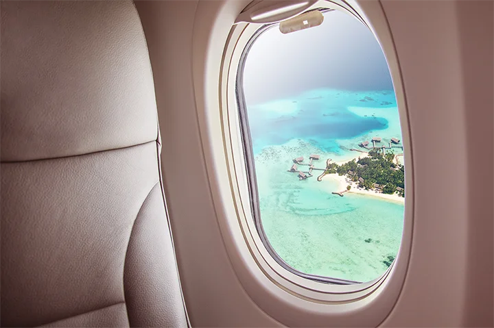 Vue aérienne d’une île paradisiaque des Maldives depuis le hublot d’un avion