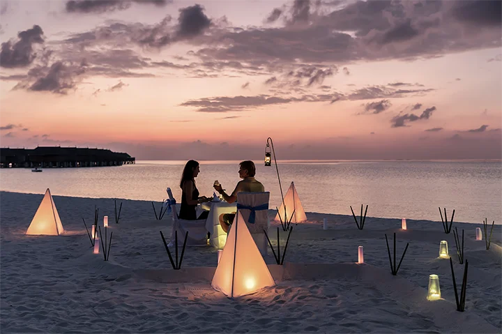 Dîner privé au coucher du soleil sur une plage de sable blanc aux Maldives
